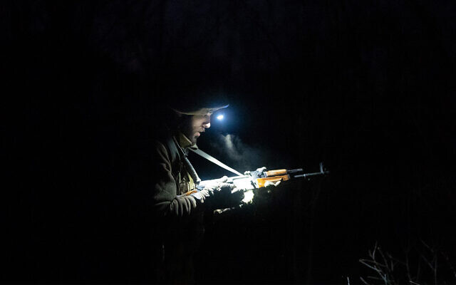 A Ukrainian serviceman lights his weapon at the conflict line near Zolote, Ukraine, February 19, 2022. (AP Photo/Evgeniy Maloletka)