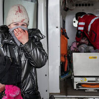 A woman reacts as paramedics perform CPR on a girl who was injured during shelling, at a city hospital of Mariupol, eastern Ukraine, February 27, 2022. The girl did not survive. (AP Photo/Evgeniy Maloletka)