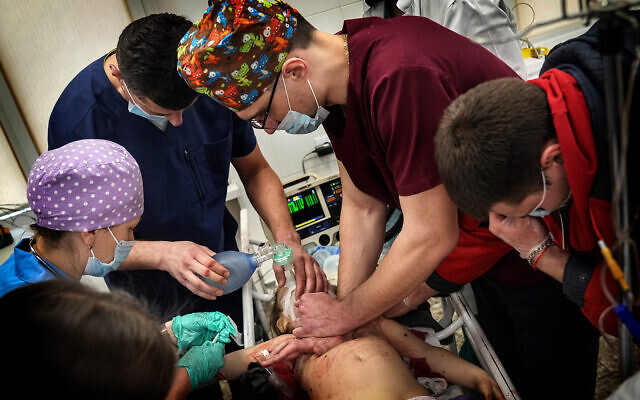 Medics perform CPR on a girl at the city hospital of Mariupol, who was injured during shelling in a residential area in eastern Ukraine, on February 27, 2022. The girl did not survive. (AP Photo/Evgeniy Maloletka)