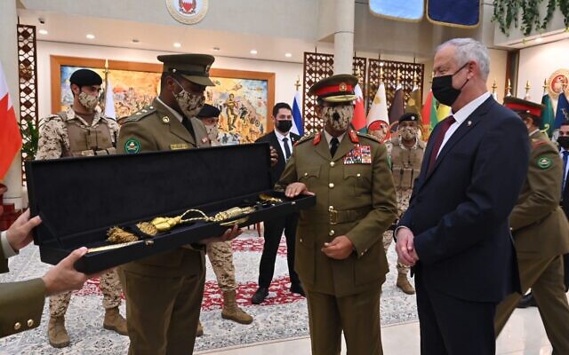 Bahraini military officers present Defense Minister Benny Gantz with a ceremonial sword after the signing of a memorandum of understanding at the Bahraini defense headquarters, on February 3, 2022. (Ariel Hermoni/Defense Ministry)