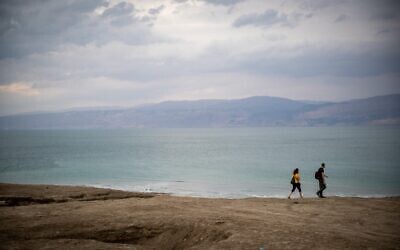 People walk along the shore of the Dead Sea on November 5, 2020. (Yonatan Sindel/Flash90)