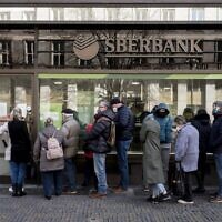 This file photo from February 25, 2022, shows people lining up outside a branch of the Russian state-owned bank Sberbank in Prague to withdraw their savings and close their accounts before Sberbank closed all its branches in the Czech Republic. (Michal Cizek/AFP)