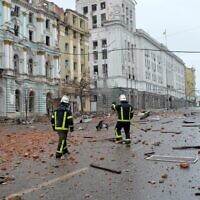 Firefighters walk  among damages after the shelling by Russian forces of Constitution Square in Kharkiv, Ukraine's second-biggest city, on March 2, 2022. (Sergey BOBOK / AFP)