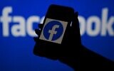 In this illustrative file photo, a smartphone screen displays the logo of Facebook on a Facebook website background, on April 7, 2021, in Arlington, Virginia. (Olivier Douliery/AFP)
