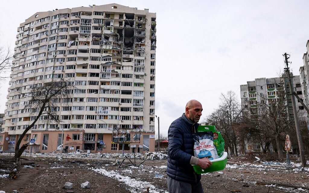 A man walks in front of a residential building damaged in yesterday's shelling in the city of Chernihiv on March 4, 2022. (Dimitar DILKOFF / AFP)