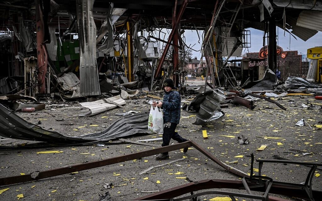 A child evacuates the city of Irpin, northwest of Kyiv, during heavy shelling and bombing on March 5, 2022, ten days after Russia launched a military invasion on Ukraine. (Aris Messinis / AFP)