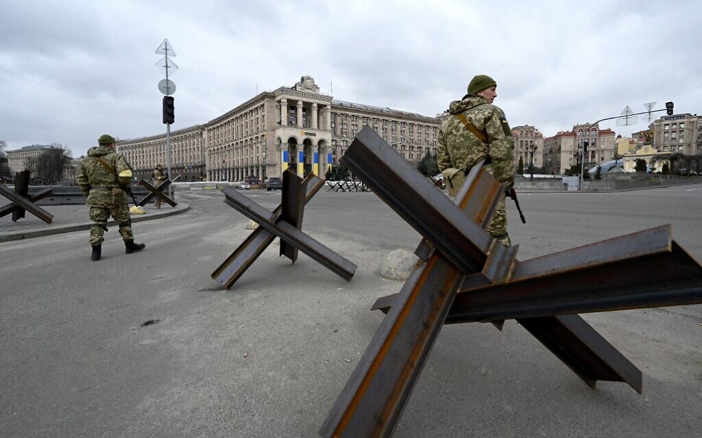 Members of the Ukrainian Territorial Defense Forces stand guard next to anti-tank structures blocking the streets of the center of Kyiv on March 6, 2022. (Sergei Supinsky/AFP)