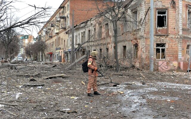 A member of the Ukrainian Territorial Defence Forces looks at destructions following a shelling in Ukraine's second-biggest city of Kharkiv on March 7, 2022. (Sergey BOBOK / AFP)