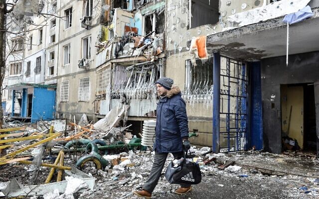 A man leaves an apartment building damaged after shelling the day before in Ukraine's second-biggest city of Kharkiv on March 8, 2022. (Sergey BOBOK / AFP)