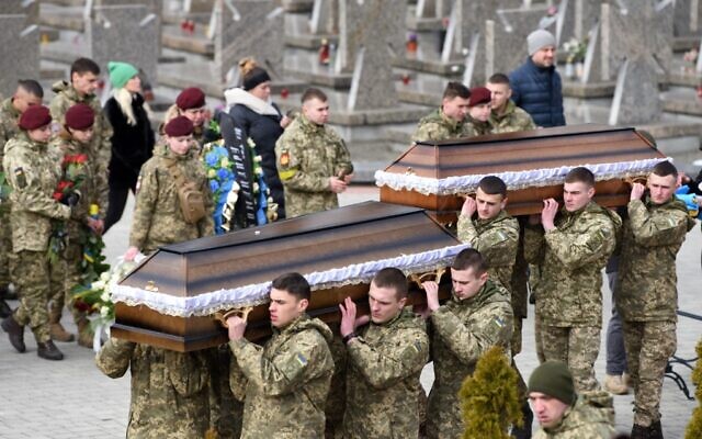 Servicemen carry the coffins of troops killed during Russia's invasion of Ukraine, at Lychakiv cemetery in the western Ukrainian city of Lviv, on March 9, 2022. (Yuriy Dyachyshy/AFP)