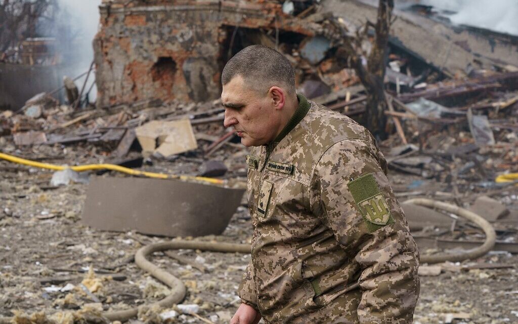 Ukraine army public affairs officer Valentin Yermolenko walks in front of a destroyed shoe factory following an airstrike in Dnipro on March 11, 2022. (Emre Caylak / AFP)