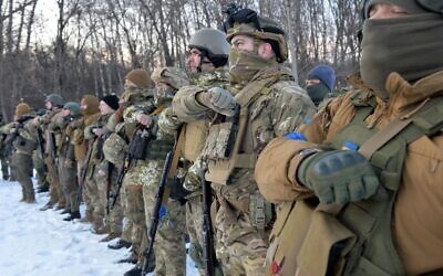 Servicemen of Ukraine's Azov Battalion pray in the Ukraine's second-biggest city of Kharkiv on March 11, 2022, following Russia's invasion of Ukraine. (Sergey BOBOK / AFP)