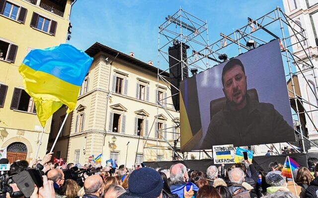 A giant screen displays an image of Ukrainian President Volodymyr Zelensky speaking through a video link at a peace rally for Ukraine, on March 12, 2022, in Florence, Italy. (Carlo Bressan/AFP)