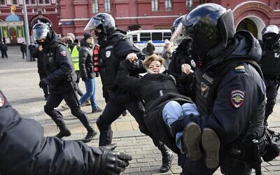Police officers detain a woman during a protest against Russian military action in Ukraine, in Manezhnaya Square in central Moscow on March 13, 2022. (AFP)