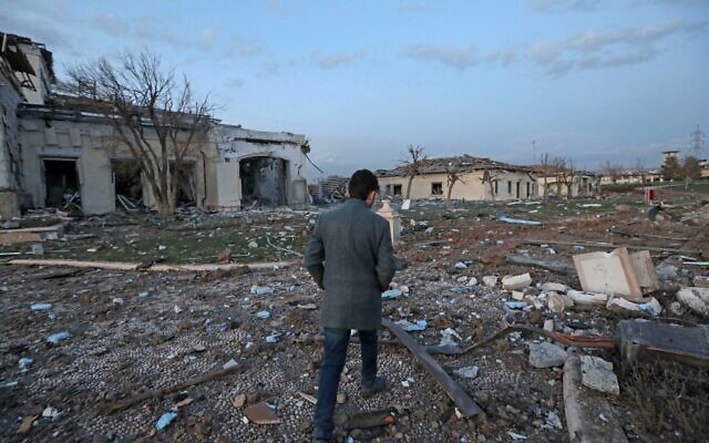 A man walks past damaged mansions following an overnight attack in Irbil, the capital of the northern Iraqi Kurdish autonomous region, March 13, 2022. (SAFIN HAMED / AFP)