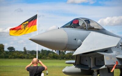 This file photo taken on August 20, 2020, shows a man taking pictures of an Eurofighter jet of the German Air Force on the tarmac of the German Armed Forces (Bundeswehr) airbase in Noervenich, western Germany. (SASCHA SCHUERMANN / AFP)