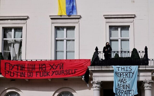 A group of squatters displayed banners and a Ukrainian national flag on the façade of a mansion supposedly belonging to Russian oligarch Oleg Deripaska in Belgrave Square, central London, on March 14, 2022 (Tolga Akmen / AFP)