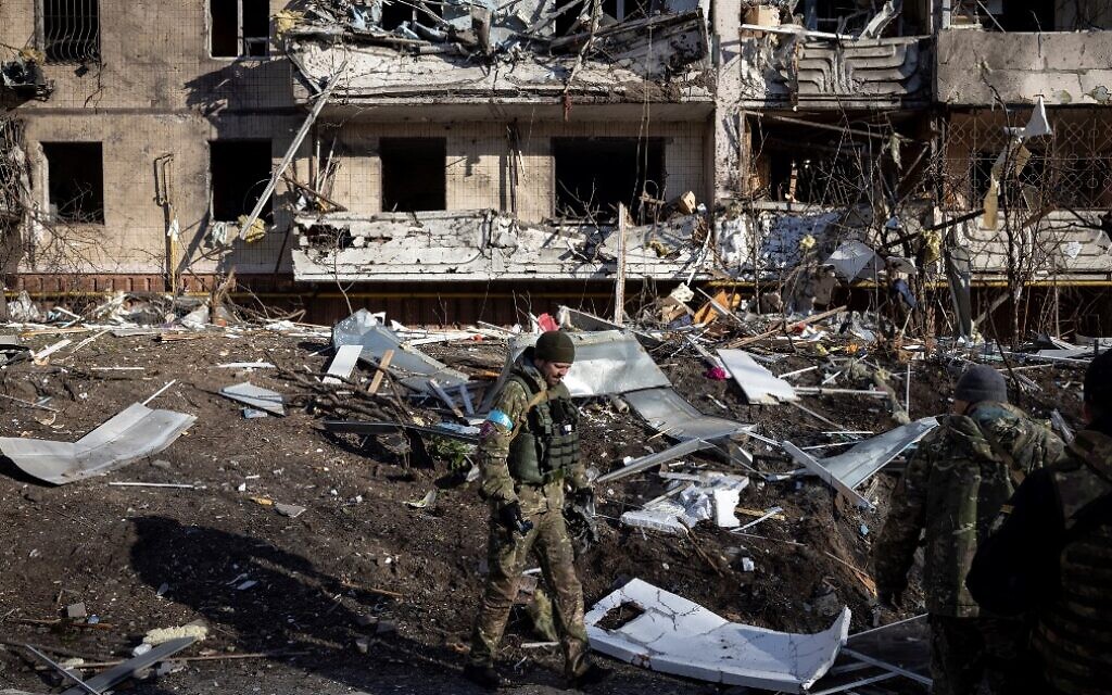 A Ukraine soldier inspects the rubble of a destroyed apartment building in Kyiv on March 15, 2022, after strikes on residential areas. (Fadel Senna/AFP)