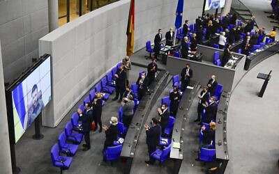 Ukrainian President Volodymyr Zelensky (on screen) gets a standing ovation by the members of the government and of parliament after he addressed via videolink the German lower house of parliament Bundestag, on March 17, 2022 in Berlin. (Tobias SCHWARZ / AFP)