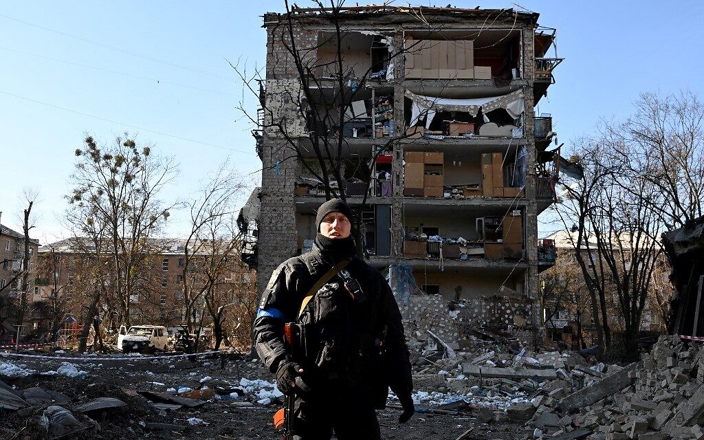 A Ukrainian policeman secures the area by a five-story residential building that partially collapsed after a shelling in Kyiv on March 18, 2022, as Russian troops try to encircle the Ukrainian capital as part of their slow-moving offensive (Sergei SUPINSKY / AFP)