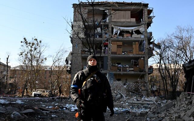 A Ukrainian policeman secures the area by a five-story residential building that partially collapsed after a shelling in Kyiv on March 18, 2022, as Russian troops try to encircle the Ukrainian capital as part of their slow-moving offensive (Sergei SUPINSKY / AFP)