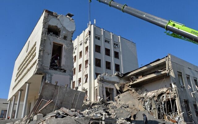 Rescue workers clear the rubble of a building of the Kharkiv Regional Institute of Public Administration damaged by shelling in Kharkiv on March 18, 2022. (Sergey BOBOK / AFP)
