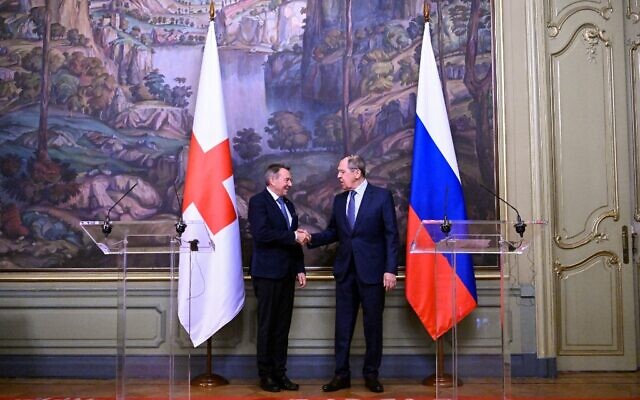 Russian Foreign Minister Sergei Lavrov and International Committee of the Red Cross (ICRC) President Peter Maurer shake hands at the end of a joint press conference following their talks in Moscow on March 24, 2022. (Kirill KUDRYAVTSEV / POOL / AFP)