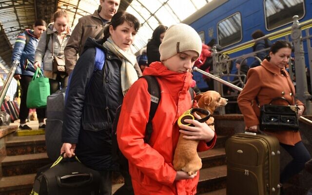 Evacuees from areas including the city of Dnipro walk in the railway station of the western Ukrainian city of Lviv on March 25, 2022, following Russia's military invasion launched on Ukraine. (Yuriy Dyachyshyn / AFP)