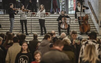 Musicians play for people living in a metro station used as a bomb shelter in Kharkiv, Ukraine, on March 26, 2022. (Aris Messinis/AFP)