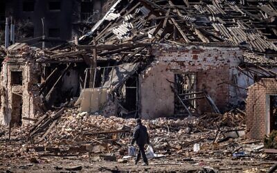 A resident walks in front of a destroyed building in the northeastern city of Trostyanets, on March 29, 2022. (FADEL SENNA / AFP)