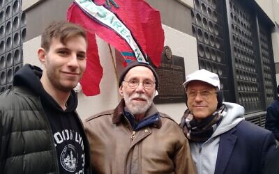 Martin Abramowitz, center, and his sons Jacob, left, and Yosef pose at the site of the Triangle Shirtwaist Factory fire, at 29 Washington Place in Greenwich Village. The original building is gone but the site is marked with a plaque. (Courtesy Martin Abramowitz/ via JTA)