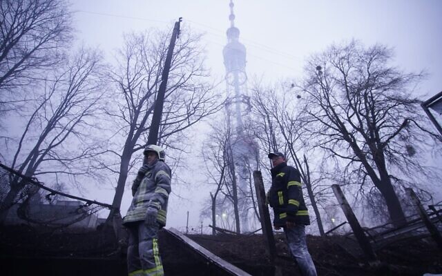 Ukrainian firefighters stand beneath a television broadcast tower in the Jewish cemetery located in Kyiv's Babi Yar Holocaust memorial site on March 1, 2022. (State Emergency Service of Ukraine)