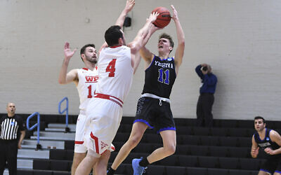 Yeshiva guard Ryan Turell (11) shoots over Worcester Polytechnic Institute forward Jake Wisniewski (4) during the second half of an NCAA DIII college basketball game that allowed no spectators on March 6, 2020, in Baltimore, Md. (AP Photo/Terrance Williams)