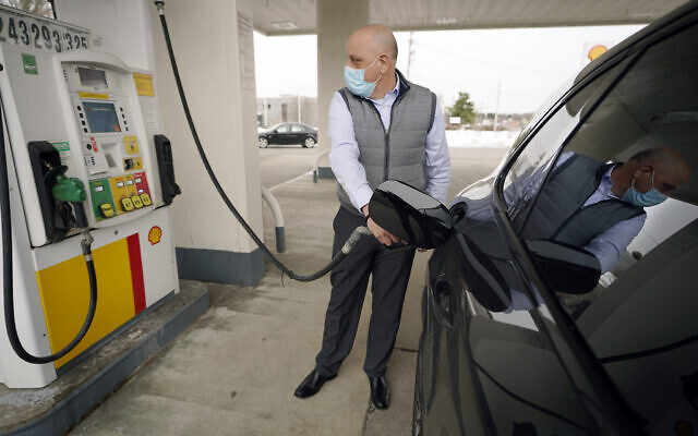 FILE - In this Feb. 18, 2021 file photo, a man pumps gasoline at a Shell gas station, in Westwood, Massachusetts (AP Photo/Steven Senne, File)