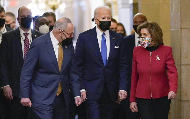 US President Joe Biden is flanked by Senate Majority Leader Chuck Schumer of N.Y., left, and House Speaker Nancy Pelosi of Calif., right, after arriving on Capitol Hill in Washington, Jan. 6, 2022.  (AP Photo/Susan Walsh, File)