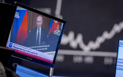 Russia's President Vladimir Putin appears on a television screen at the stock market in Frankfurt, Germany, Feb. 25, 2022. (AP Photo/Michael Probst, File)