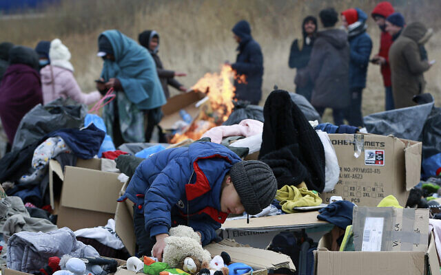 A child collects toys near a clothes donation point as refugees fleeing conflict in Ukraine arrive at the Medyka border crossing in Poland, on February 28, 2022. (AP Photo/Visar Kryeziu)