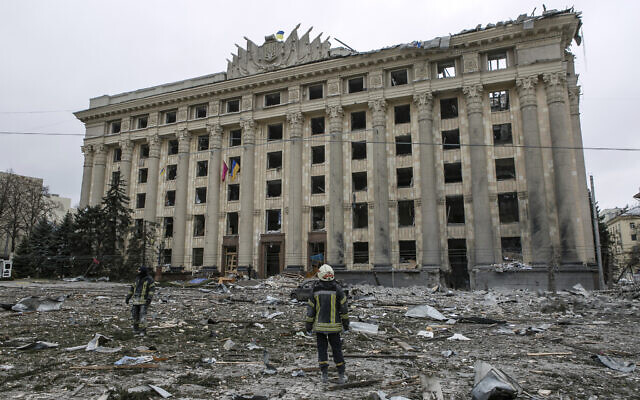 A member of the Ukrainian Emergency Service looks at the City Hall building in the central square following shelling in Kharkiv, Ukraine, March 1, 2022. (AP Photo/Pavel Dorogoy)