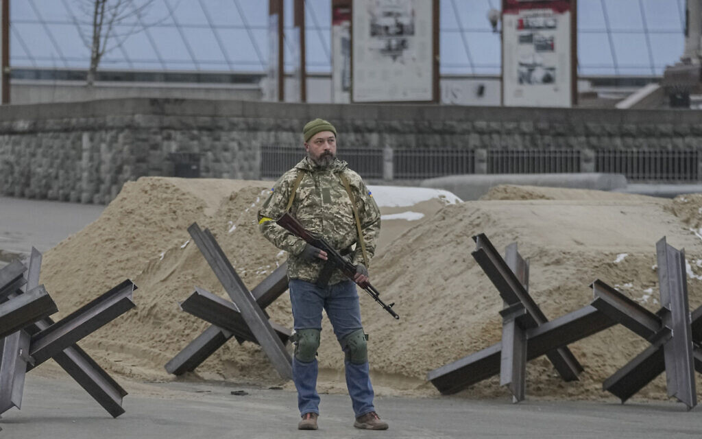 An armed man stands near a barricade during an air raid alarm in Maidan Square, in Kyiv, Ukraine, March 1, 2022. (AP Photo/Vadim Ghirda)