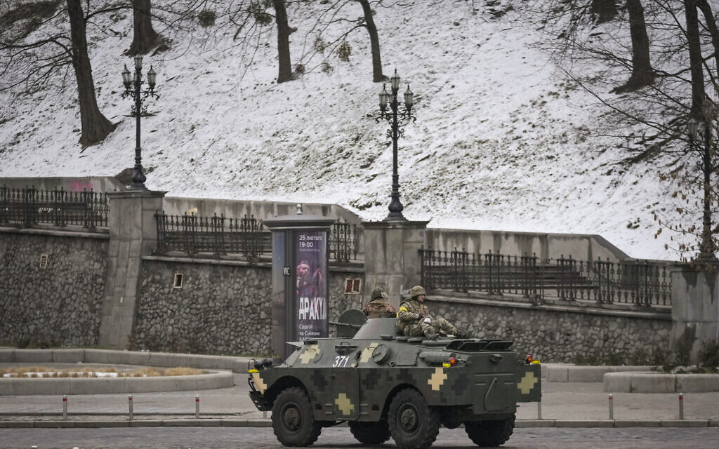 Ukrainian servicemen ride on top of an armored personnel carrier speeding down a deserted boulevard during an air raid alarm, in Kyiv, Ukraine, Tuesday, March 1, 2022. The U.N.'s refugees chief is warning that many more vulnerable people will begin fleeing their homes in Ukraine if Russia's military offensive continues and further urban areas are hit. (AP Photo/Vadim Ghirda)