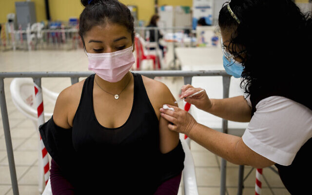 A healthcare worker administers an AstraZeneca booster shot for COVID-19 at a vaccination center in Guatemala City, March 1, 2022.  (AP Photo/Moises Castillo)
