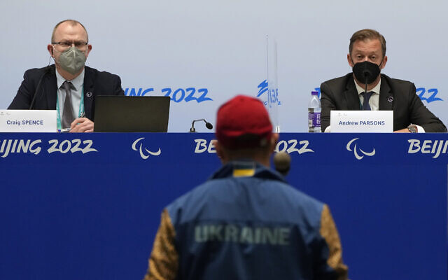 International Paralympic Committee (IPC) Chief Brand and Communications Officer Craig Spence, left, and President Andrew Parsons listen as a journalist from Ukraine asks a question during a press conference at the 2022 Winter Paralympics in Beijing, March 2, 2022. (AP Photo/Andy Wong)