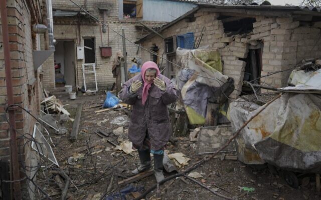 A woman stands in the backyard of a house damaged by a Russian airstrike, according to locals, in Gorenka, outside the capital Kyiv, Ukraine, Wednesday, March 2, 2022 (AP Photo/Vadim Ghirda)