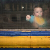 A baby sits with his mother inside a train leaving the Lviv railway station, in Lviv, west Ukraine, March 2, 2022. (AP Photo/Felipe Dana)