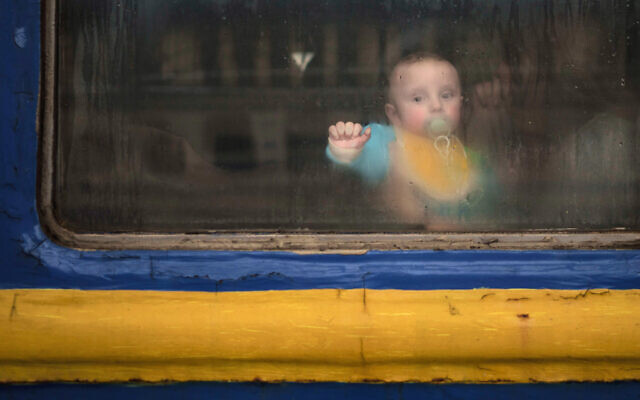 A baby sits with his mother inside a train leaving the Lviv railway station, in Lviv, west Ukraine, March 2, 2022. (AP Photo/Felipe Dana)
