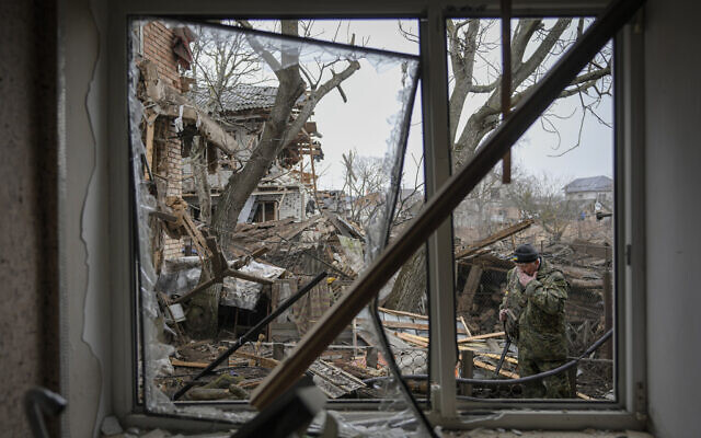 Andrey Goncharuk, 68, a member of territorial defense, wipes his face in the backyard of a house that was damaged by a Russian airstrike, according to locals, in Gorenka, outside the capital Kyiv, Ukraine, March 2, 2022. (AP Photo/Vadim Ghirda)