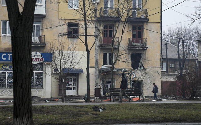 A man walks past an apartment building hit by shelling in Mariupol, Ukraine, on March 2, 2022. (AP Photo/Evgeniy Maloletka)