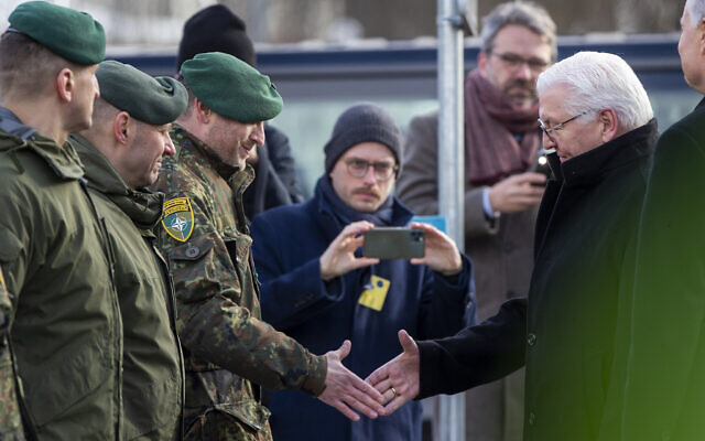German President Frank-Walter Steinmeier, right, greets Lieutenant Colonel Daniel Andra, the commander of the multi-national NATO Enhanced Forward Presence battalion in Lithuania during a visit to the Rukla military base some 100 km (62.12 miles) west of the capital Vilnius, Lithuania, on March 3, 2022. (AP Photo/Mindaugas Kulbis)