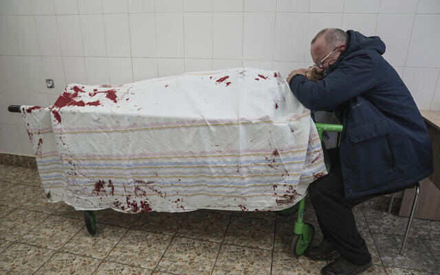 Serhii, father of teenager Iliya, cries on his son's lifeless body lying on a stretcher at a maternity hospital converted into a medical ward in Mariupol, Ukraine, on March 2, 2022. (AP/Evgeniy Maloletka)