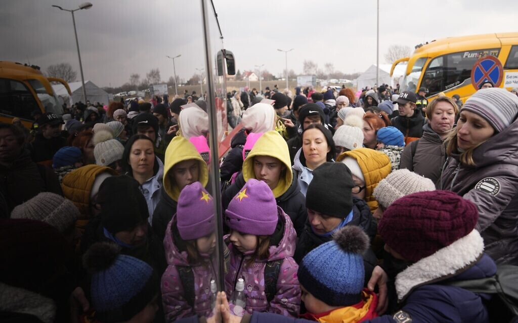 People fleeing from Ukraine queue to board on a bus at the border crossing in Medyka, Poland, Friday, March 4, 2022. (AP Photo/Markus Schreiber)